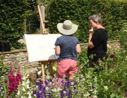Artist Natasha Clutterbuck helping a student get inspriation from the yeo valley organic garden
